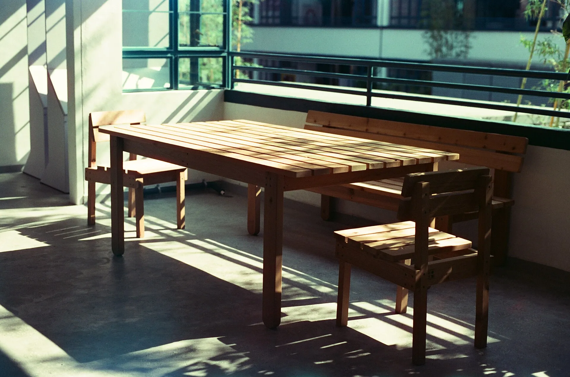 Grande table et bancs en bois massif dans une pièce baignée de soleil